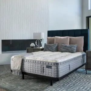 King Koil Pacific Firm EuroTop mattress displayed in a stylish bedroom setting with decorative pillows and a modern headboard, highlighting luxury bedding options.