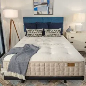 King Koil Willow Haven Luxury Plush Blisstop mattress displayed on a stylish bed frame, featuring decorative pillows and a cozy throw blanket, in a well-lit bedroom setting.