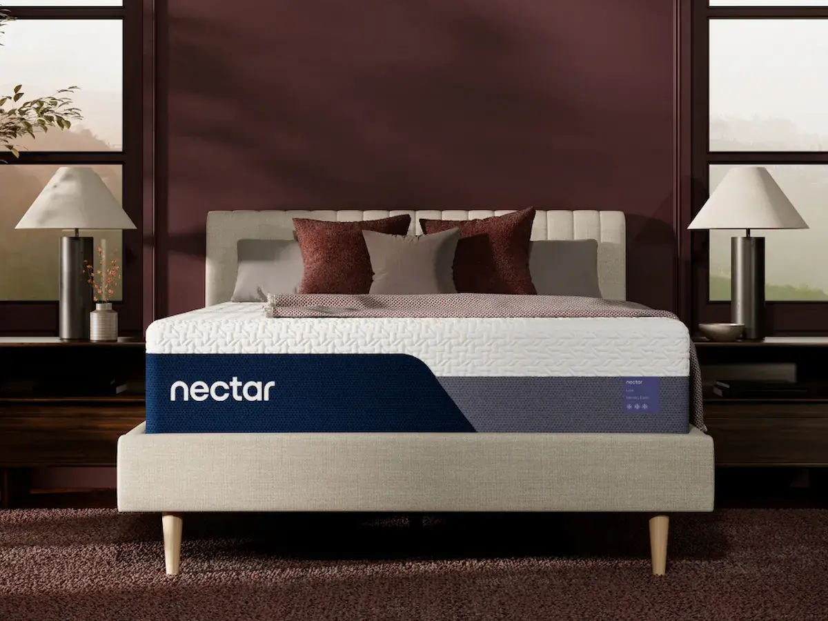 Nectar Luxe Memory Foam 1 Nectar Luxe Memory Foam mattress on a stylish bed frame with decorative pillows and lamps, showcasing premium design and comfort features.