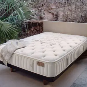 King Koil mattress displayed in a natural setting with greenery, featuring a plush tufted design and a light-colored fabric cover, emphasizing comfort and quality for bedding options.