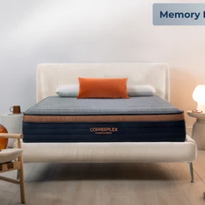 Copper Flex mattress displayed on a stylish bed frame with an orange accent pillow, showcasing its memory foam design in a modern bedroom setting.