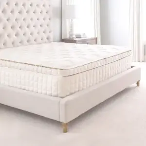 Naturepedic EOS Organic Pillow Top Mattress on a modern bed frame in a bright, airy bedroom setting.